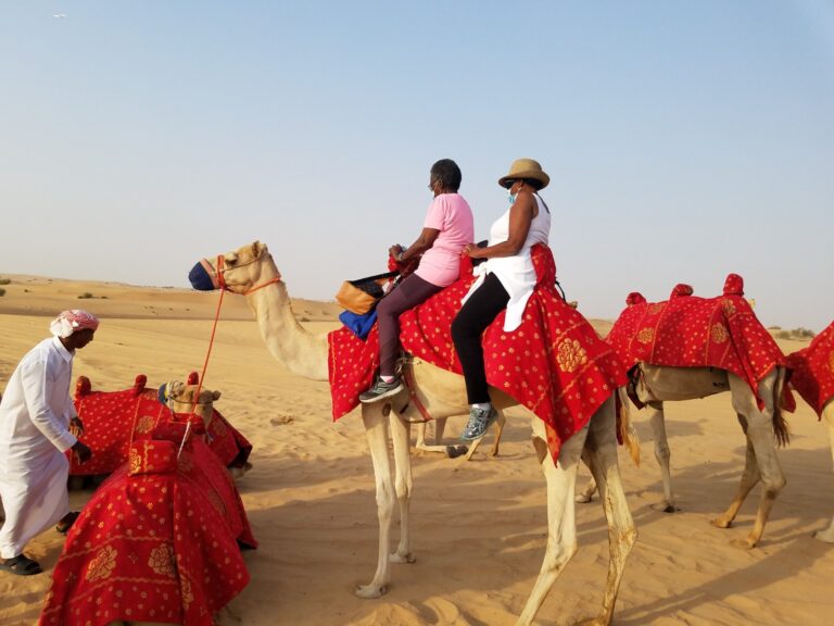 Two women sat on the moving camel